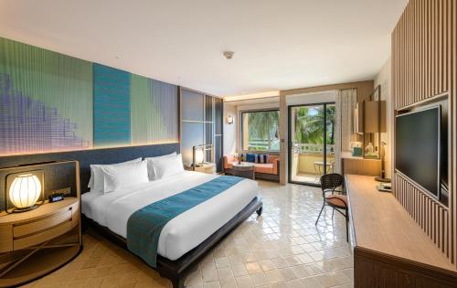 a hotel room with a bed and a television at Holiday Inn Resort Phuket, an IHG Hotel in Patong Beach