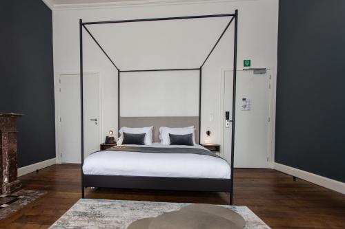 a bedroom with a large bed with a canopy at Petit-Roannay in Stavelot