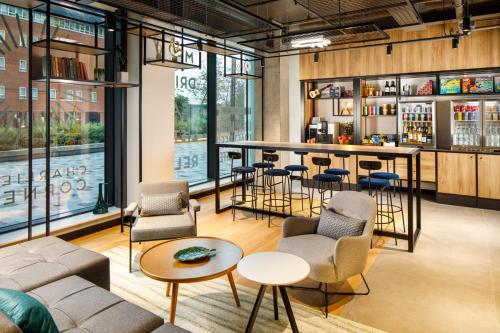 a bar in a room with chairs and tables at ibis London Sutton Point in Sutton