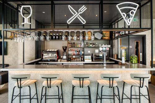 a bar with stools in front of a counter at Aparthotel Adagio London Sutton Point in Sutton