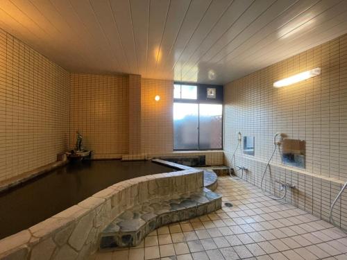 a large bathroom with a bath tub and a tub at Hotel Isodokei in Shirahama