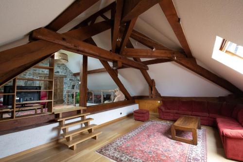 a living room with a red couch in a attic at le Relais des Bornes - Gîte & Spa in Villy-le-Bouveret