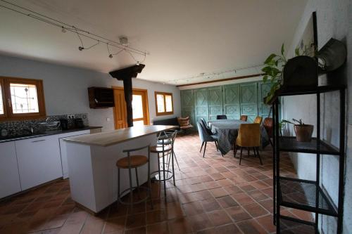 une cuisine et un salon avec une table et des chaises dans l'établissement le Relais des Bornes - Gîte & Spa, à Villy-le-Bouveret