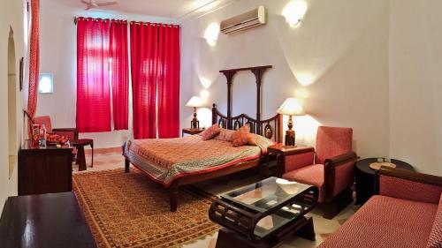 a bedroom with a bed and a living room at Neemrana Fort-Palace in Neemrana