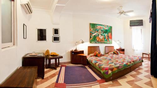 a bedroom with a bed and a desk and a table at Neemrana Fort-Palace in Neemrana