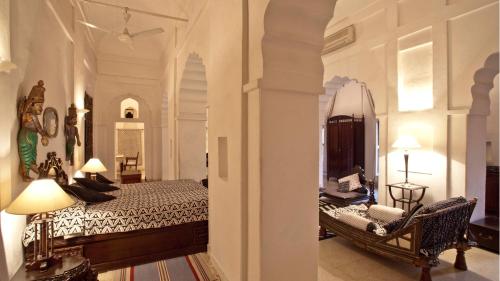 a bedroom with a bed and a chair in a room at Neemrana Fort-Palace in Neemrana
