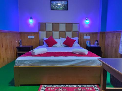 a bedroom with a large bed with purple lights at The Lachung Inn in Lachung