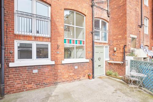 a brick building with a white door and windows at Mary Lyth - Whitby West Cliff with parking in Whitby