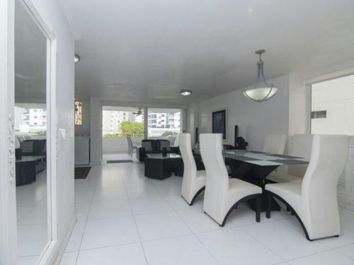 a dining room with a table and white chairs at PLAYA LAGUITO in Cartagena de Indias