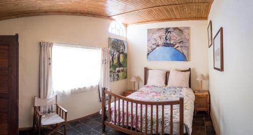 um quarto com uma cama e uma janela em Artists cottage em Ladybrand