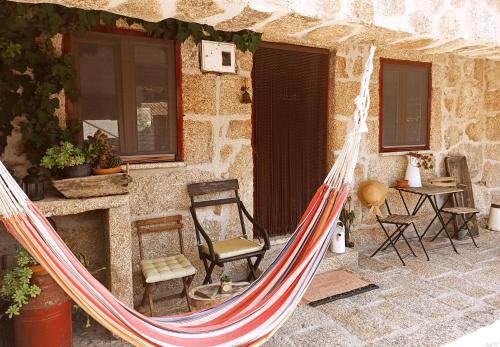 a hammock in front of a stone house at Casa da Azenha in Sortelha