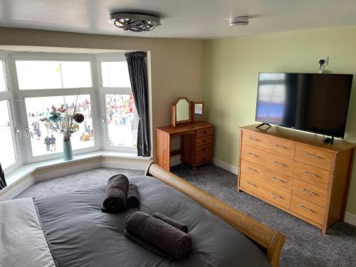 a bedroom with a large bed and a flat screen tv at HARBOUR VIEW HOLIDAY LET - Entire 3 Bedroom Maisonette With Spectacular Harbour And Sea Front Views Sleeps 5 in Bridlington