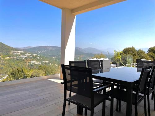 a dining room with a table and chairs on a balcony at villa I Cresti proche centre ville et plages in Ajaccio