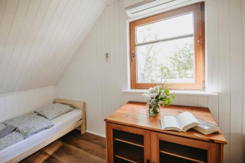 a bedroom with a bed and a desk with books at Domki letniskowe Babie Doły in Gdynia