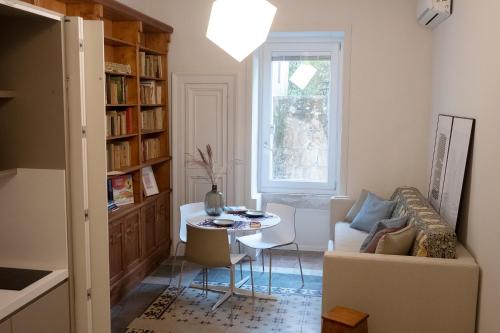 een woonkamer met een bank en een tafel bij Sognalibro Bed and Books in Ragusa