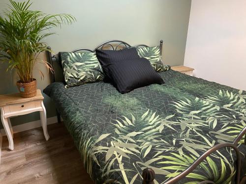 a bedroom with a bed with a green plant at Appartement aan de Mergelgrot -Cauberg Valkenburg in Valkenburg