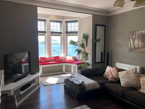 a living room with a couch and a tv at Royal Bank Flat in Oban