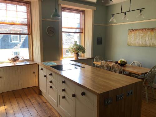 a kitchen with a island with a wooden counter top at Royal Bank Flat in Oban