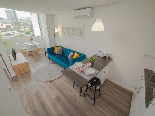 a living room with a blue couch and a table at Angel Flats in Porto