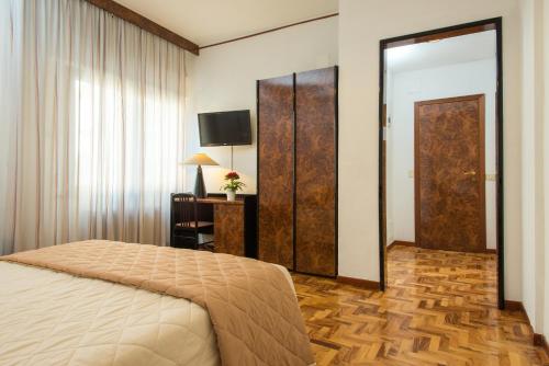 a bedroom with a bed and a mirror and a television at Royal Hotel in Cosenza