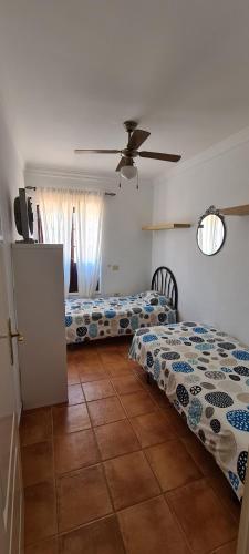 una camera con 2 letti e un ventilatore a soffitto di Casa Aitana a Puerto Calero