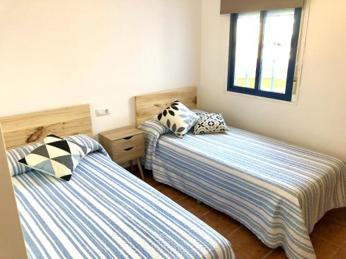 two beds in a small room with two pillows at Apartamento Cerro Negro in Las Negras