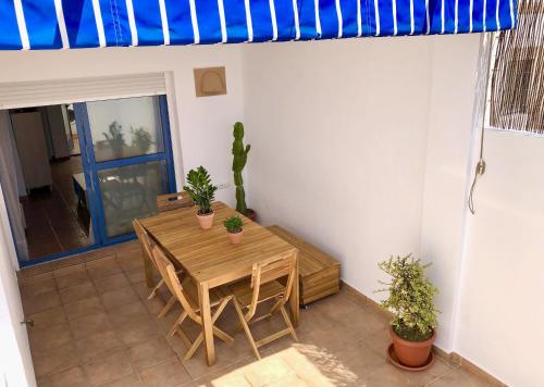 a dining room with a wooden table and a blue awning at Apartamento Cerro Negro in Las Negras