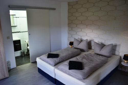 una cama blanca con almohadas en una habitación en Ferienwohnung Klüger en Liebstadt