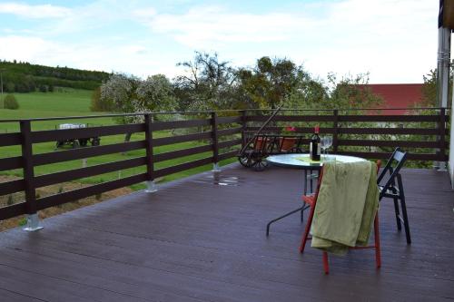 a table and chairs on a deck with a fence at Ferienwohnung Klüger in Liebstadt