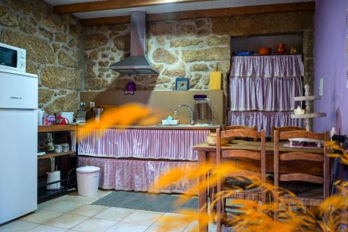 a kitchen with a table and a counter top at Casa da Azenha II in Sabugal