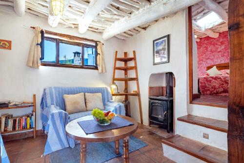 a living room with a blue couch and a table at El Gato Negro in Capileira