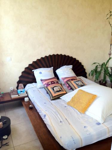 un lit avec des oreillers dessus dans une chambre dans l'établissement Coquet T3 à 500m de la mer, à Marseille