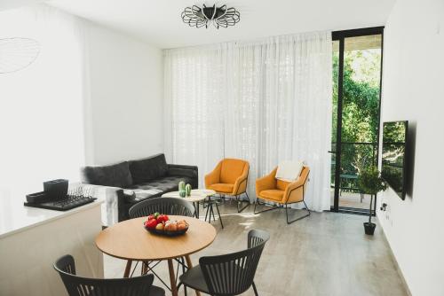salon z kanapą, krzesłami i stołem w obiekcie AirTLV - Rambam Residence W Private MAMAD! w Tel Awiwie