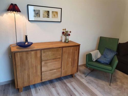 a room with a wooden cabinet and a green chair at Das Fachwerkhäuschen in Bad Pyrmont