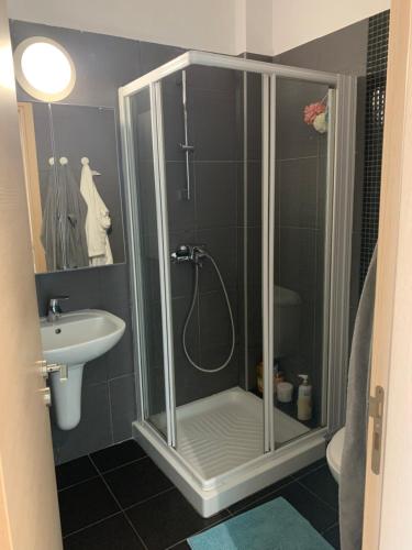 ein Bad mit einer Dusche und einem Waschbecken in der Unterkunft One-bedroom beach apartment, 30m from the best beach in Protaras