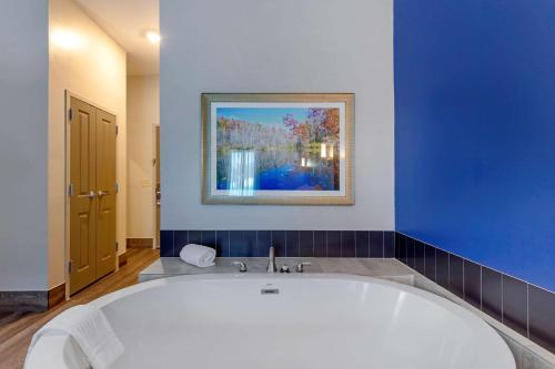 Comfort Inn & Suites East Ellijay في إليجاي: حوض استحمام في الحمام بجدار ازرق