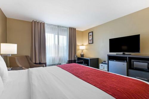 a hotel room with a bed and a flat screen tv at Comfort Inn & Suites Ponca City near Marland Mansion in Ponca City