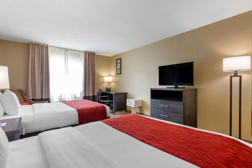 a hotel room with two beds and a flat screen tv at Comfort Inn & Suites Ponca City near Marland Mansion in Ponca City