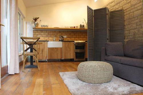 a kitchen with a couch and a table in a living room at Peaceful & Central Self Contained 1 Bedroom House in Glastonbury