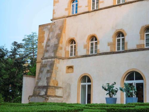 um edifício com uma planta de vasos em frente em La Citadelle Metz MGallery em Metz