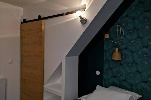 a bedroom with a bed with a black and white wall at La Dilettante, petite maison rénovée, avec jardin in Vertaizon