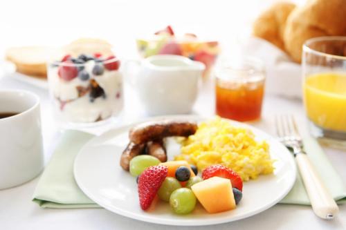 a plate of breakfast food with sausage eggs and fruit at Premier Express Inn George in George