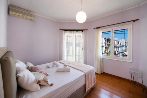 biała sypialnia z łóżkiem i oknem w obiekcie Ionian Grand - Apartments w mieście Leukada (miasto)
