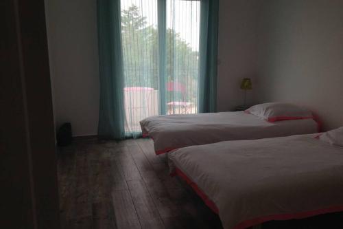 吉索納恰的住宿－Ghisonaccia, F4 de charme，酒店客房设有两张床和窗户。