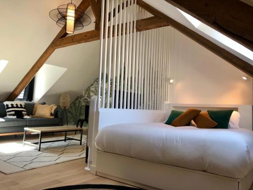 une chambre avec un lit blanc et un canapé dans l'établissement L'Entre-Deux Honfleur, à Honfleur