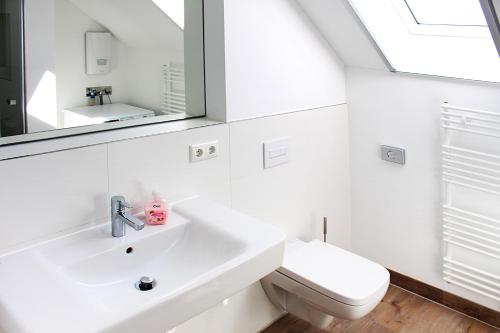 a white bathroom with a sink and a mirror at Weisses Haus Plau in Plau am See
