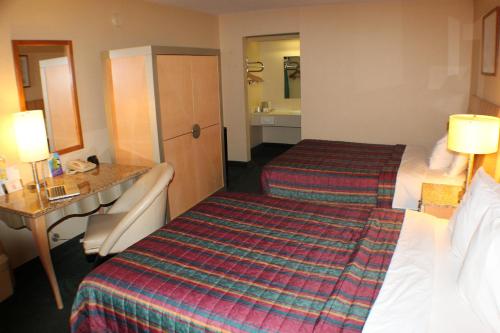 a hotel room with two beds and a sink at Days Inn by Wyndham Greeneville in Greeneville