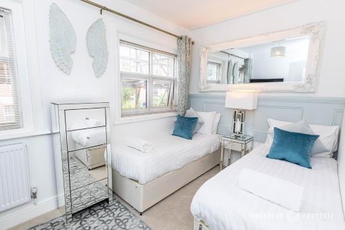 a bedroom with two beds and a mirror at Chic & Dreamy 2bed Apt with Parking - Le Chambre d Isabel in Poole