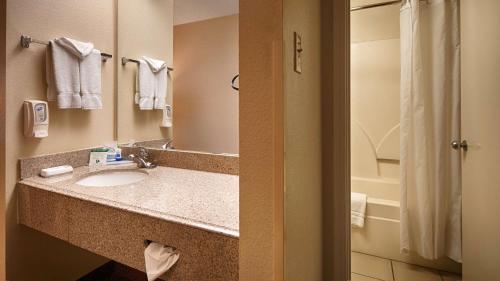 uma casa de banho do hotel com um lavatório e um chuveiro em SureStay Plus by Best Western San Antonio Fiesta Inn em San Antonio