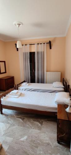 a bedroom with two beds and a window at Elena's Apartments Corfu in Ipsos